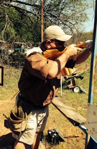 a man with a rifle aiming at a target